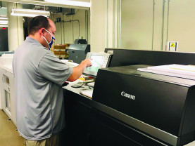 David Doerfler operates the Canon imagePRESS C10000VP digital color press.