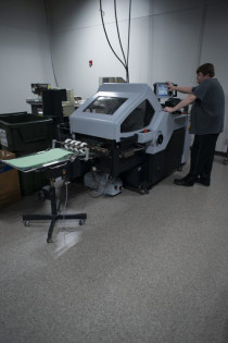 In the bindery, Paul Deason runs the in-plant&rsquo;s Horizon Cross Folder AFC-566F.