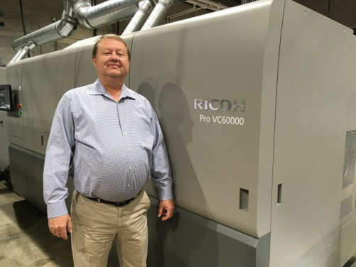 Director Doug Maxwell stands with BYU Print & Mail&rsquo;s new Ricoh Pro VC60000 continuous-feed inkjet press, which is bringing new business to the Provo, Utah, in-plant.