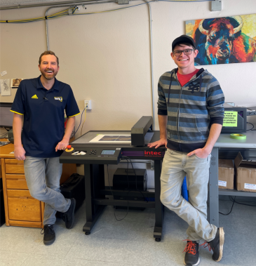 Standing with the new Intec FB750 digital diecutter at Northern Arizona University are Dylan Turner (left) and Ryan Wade.
